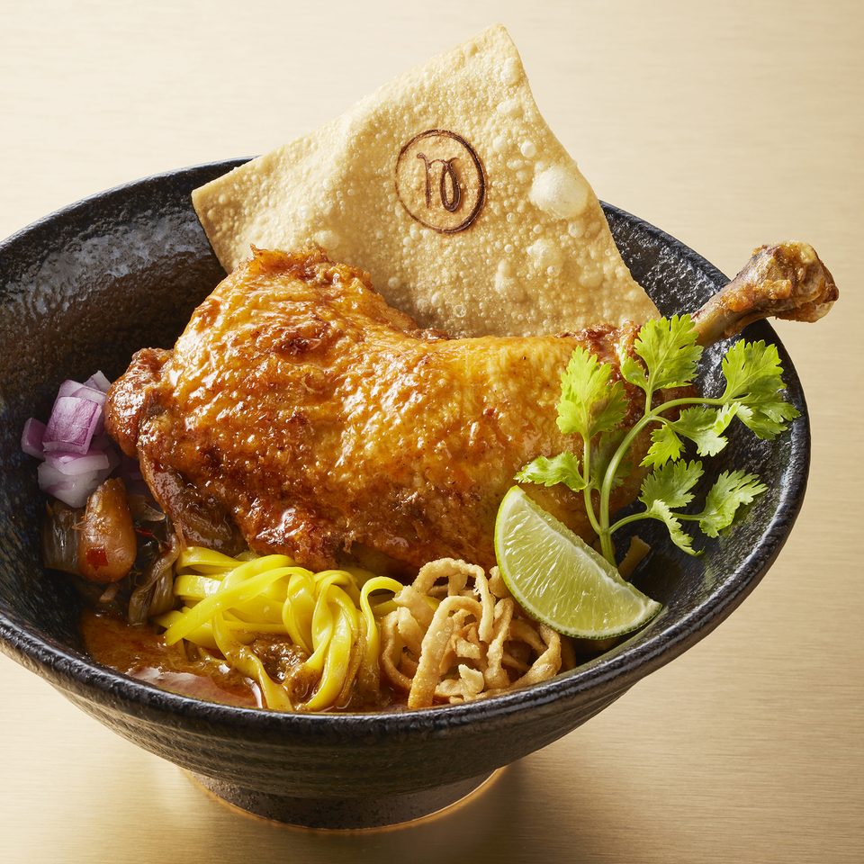 Khao soi with a heritage chicken leg, crisp noodles and lime
